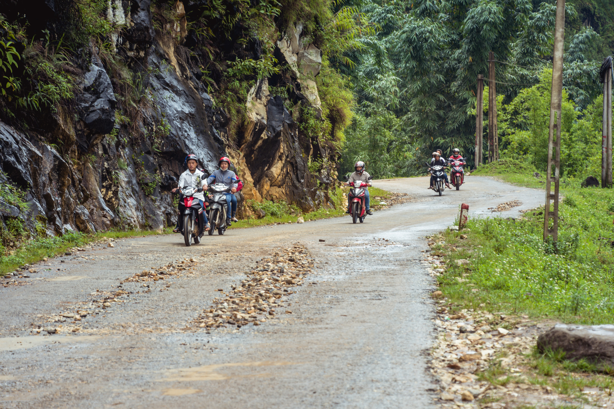 Motorbikes riding a rough road through the jungle in Vietnam