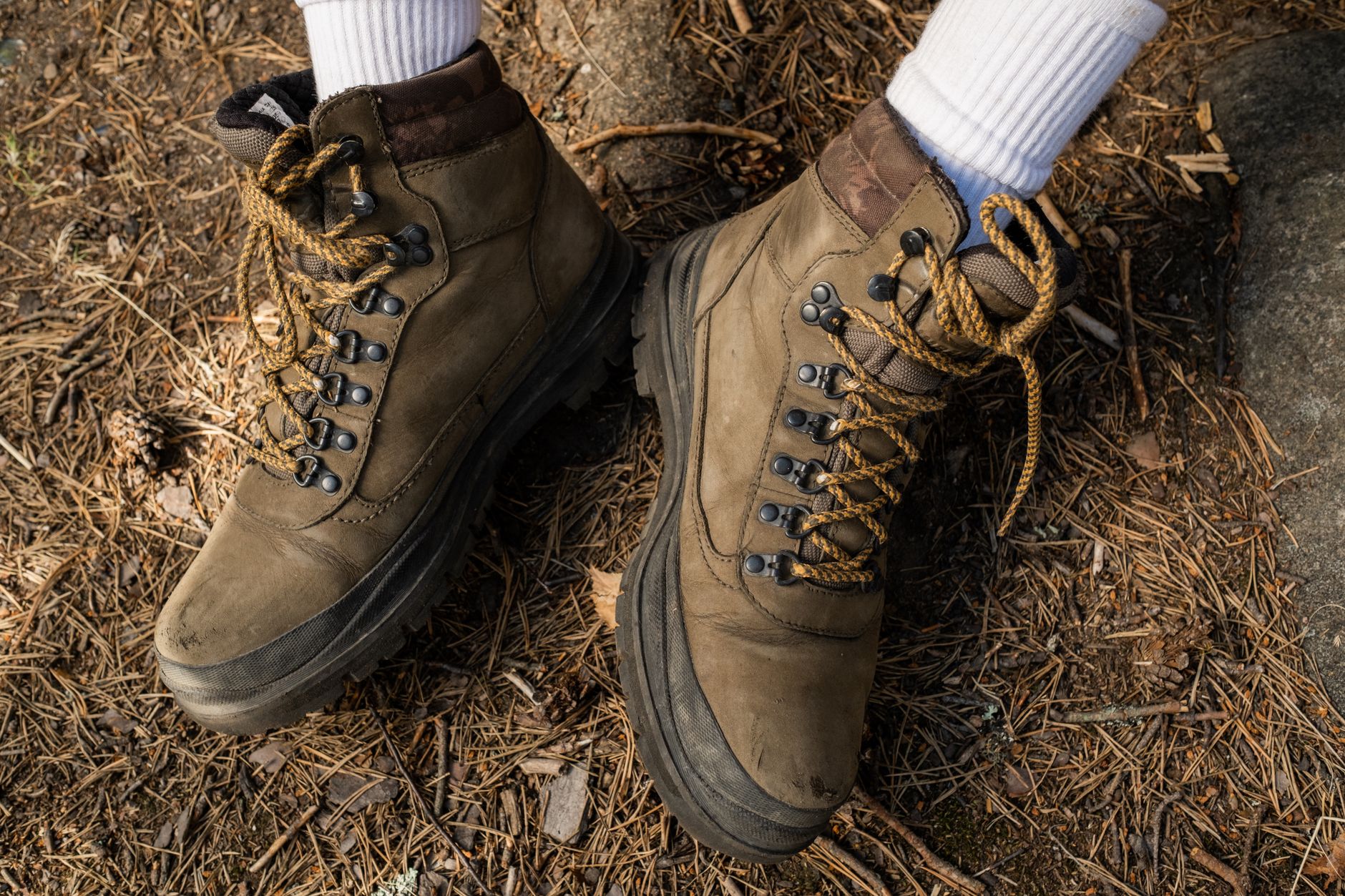 Trekking boots with long socks pulled over the trouser cuff