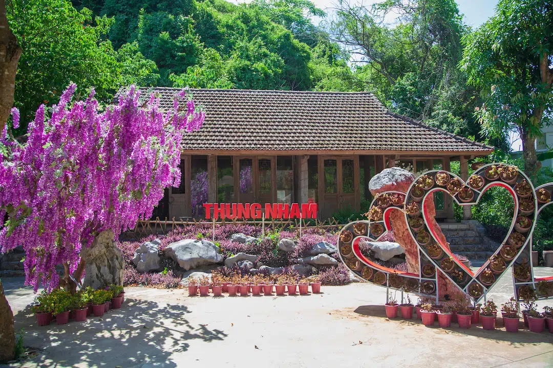 Thung Nham ecotourism park entrance with heart shaped flower displays and traditional architecture.