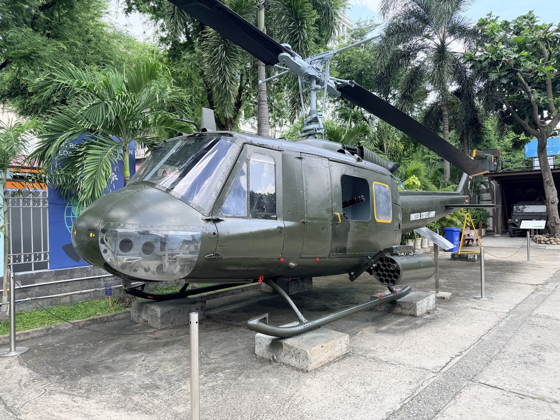 Green helicopter behind ropes in the War Remnants Museum outdoor collection