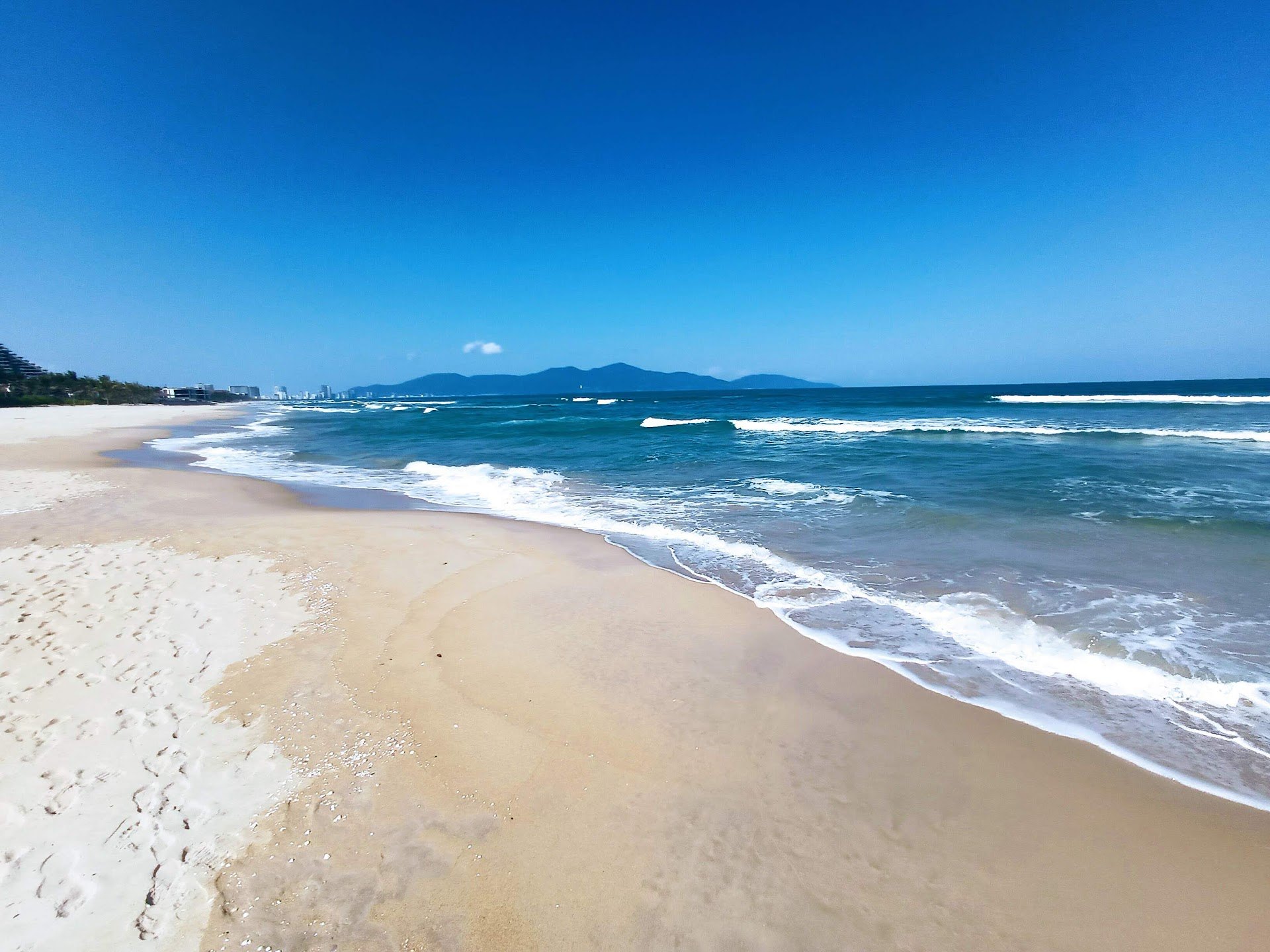 Waves breaking along the sandy shoreline of Non Nuoc Beach