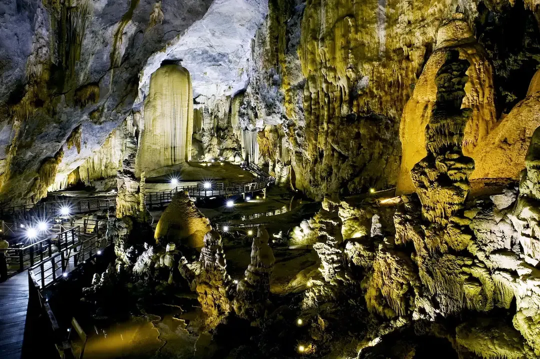 Massive underground chamber with illuminated stalactites and stalagmites inside Paradise Cave at Phong Nha Vietnam