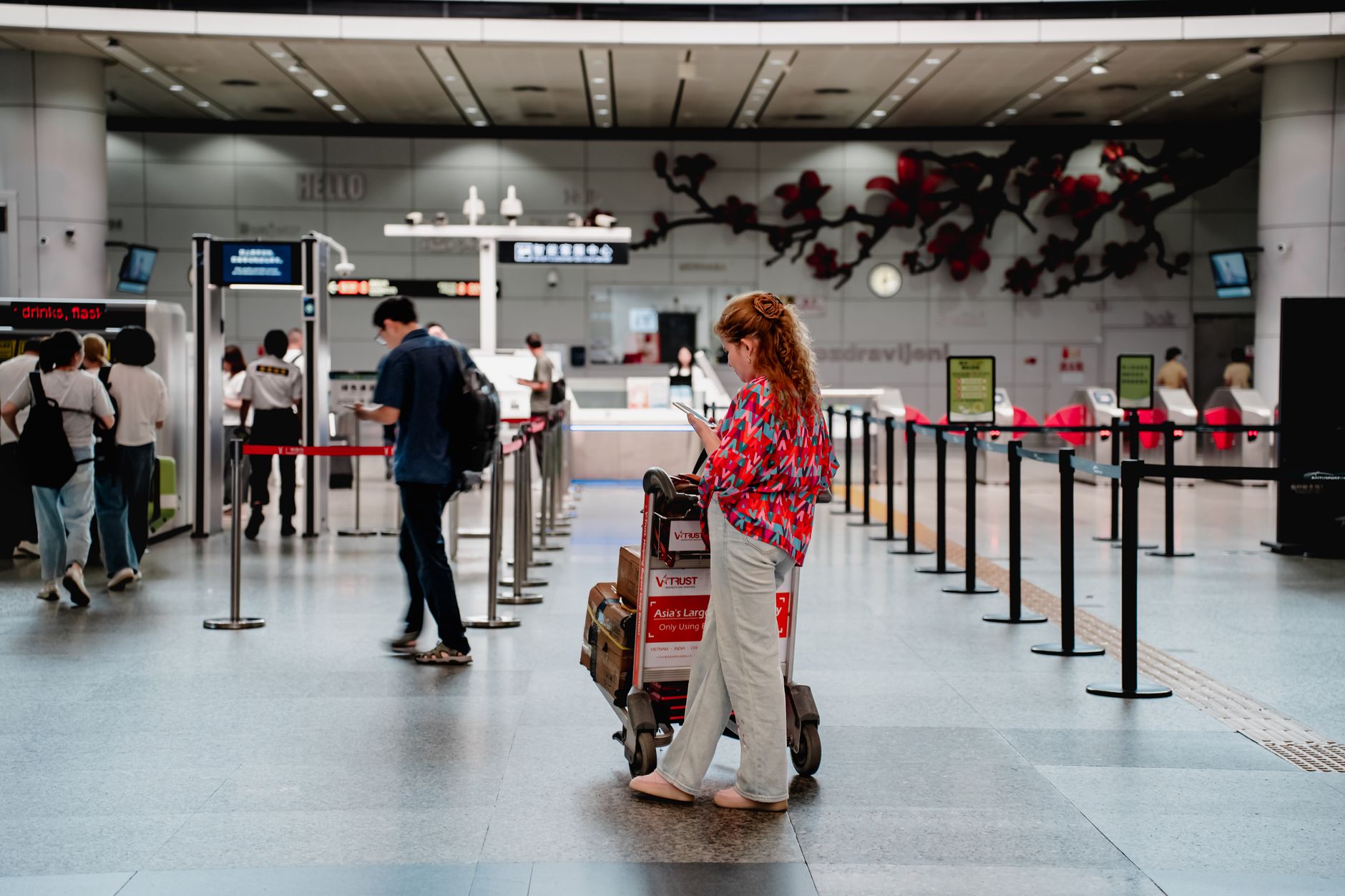 Families queueing with luggage trolleys at an international check-in desk in India