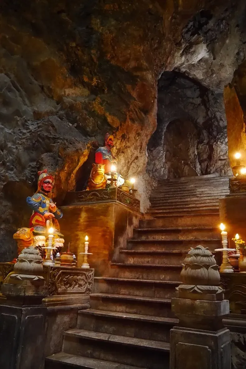 Hoa Nghiem Cave Da Nang featuring serene Bodhisattva Guan Yin statue in Water Mountain with Buddhist altar, ancient 1640 stele inscriptions, and natural sunlight illumination