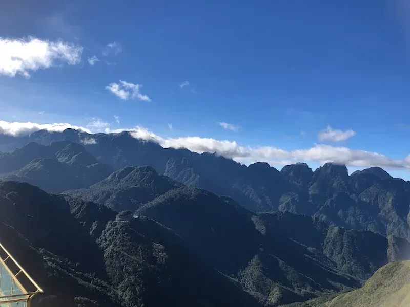 Panoramic Mountain View From the Sapa Glass Bridge Overlooking Fansipan Range Under Clear Blue Sky