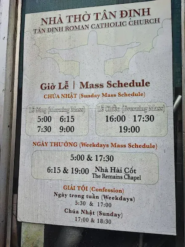 Tan Dinh Church mass schedule sign showing Sunday mass times 6:00am 7:30am 9:00am and weekday masses in Ho Chi Minh City