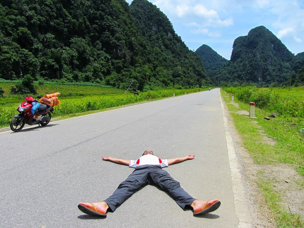 a Bike Rider Relaxing on Middle of Road on a Road Trip Covering Ha Giang Loop