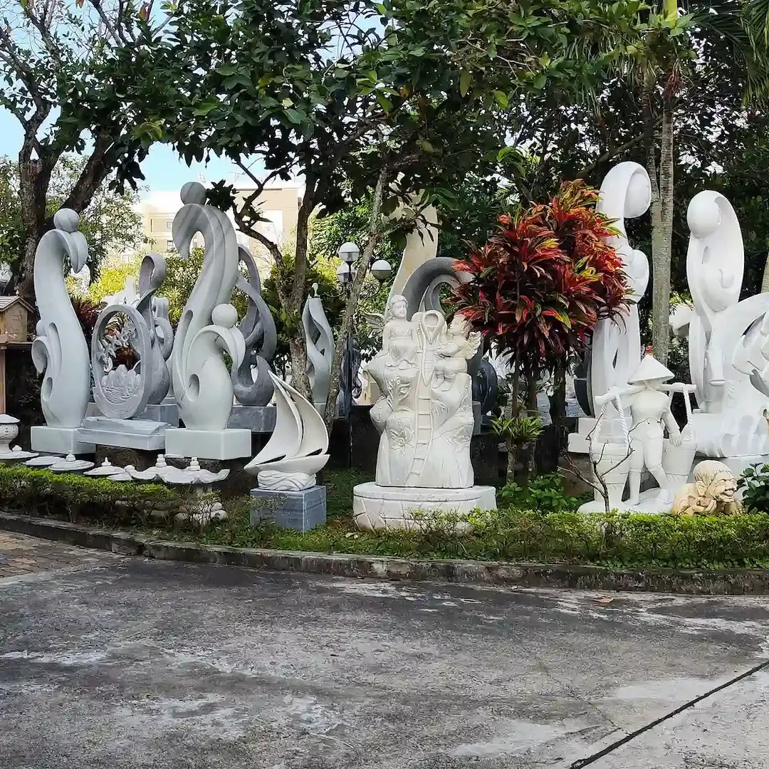 Non Nuoc Stone Carving Village Da Nang displaying white marble Buddha statues and traditional Vietnamese stone sculptures with mountain backdrop