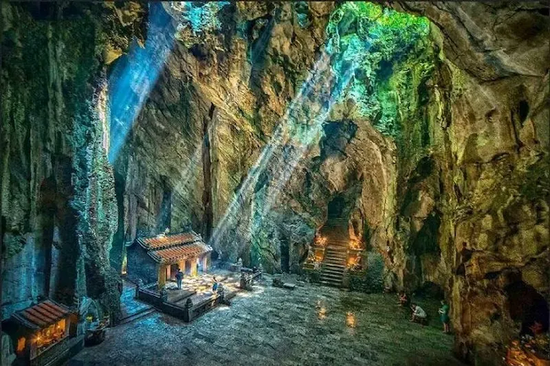 Tang Chon Cave in Marble Mountains Da Nang with ancient Buddha statues and stone temple altar inside limestone cavern