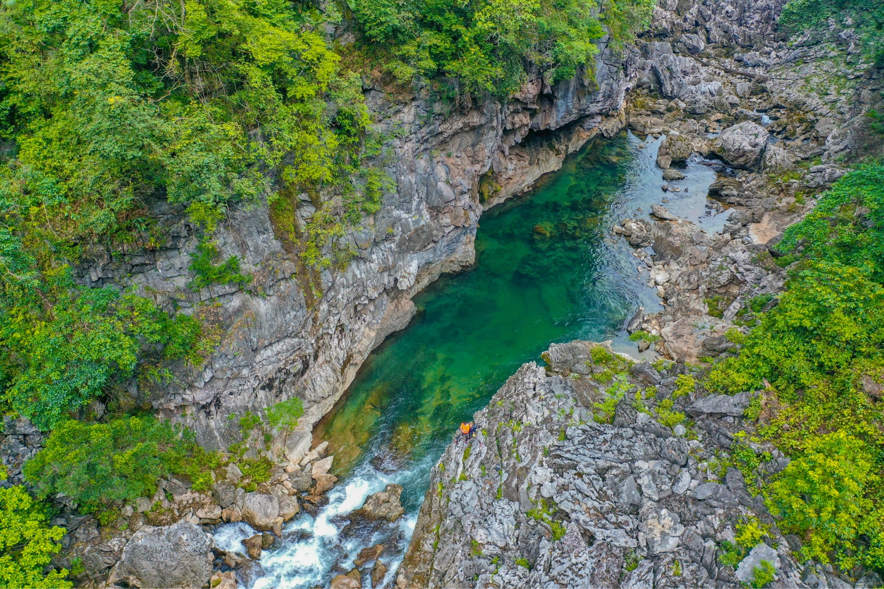 Turquoise river running through a limestone gorge below karst walls