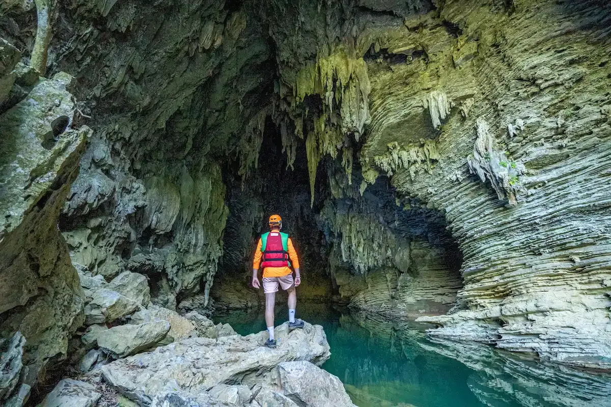 abenteurer steht neben einem unterirdischen fluss im tu lan hhlensystem auf der tu lan hhlenexpedition in phong nha vietnam