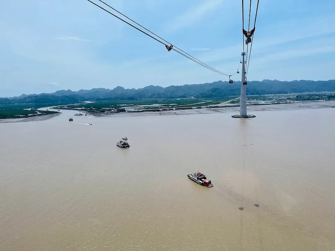 Cat Ba Island Cable Car Crossing the Bay Above Boats and Riverside Farms Near Lan Ha Bay Vietnam