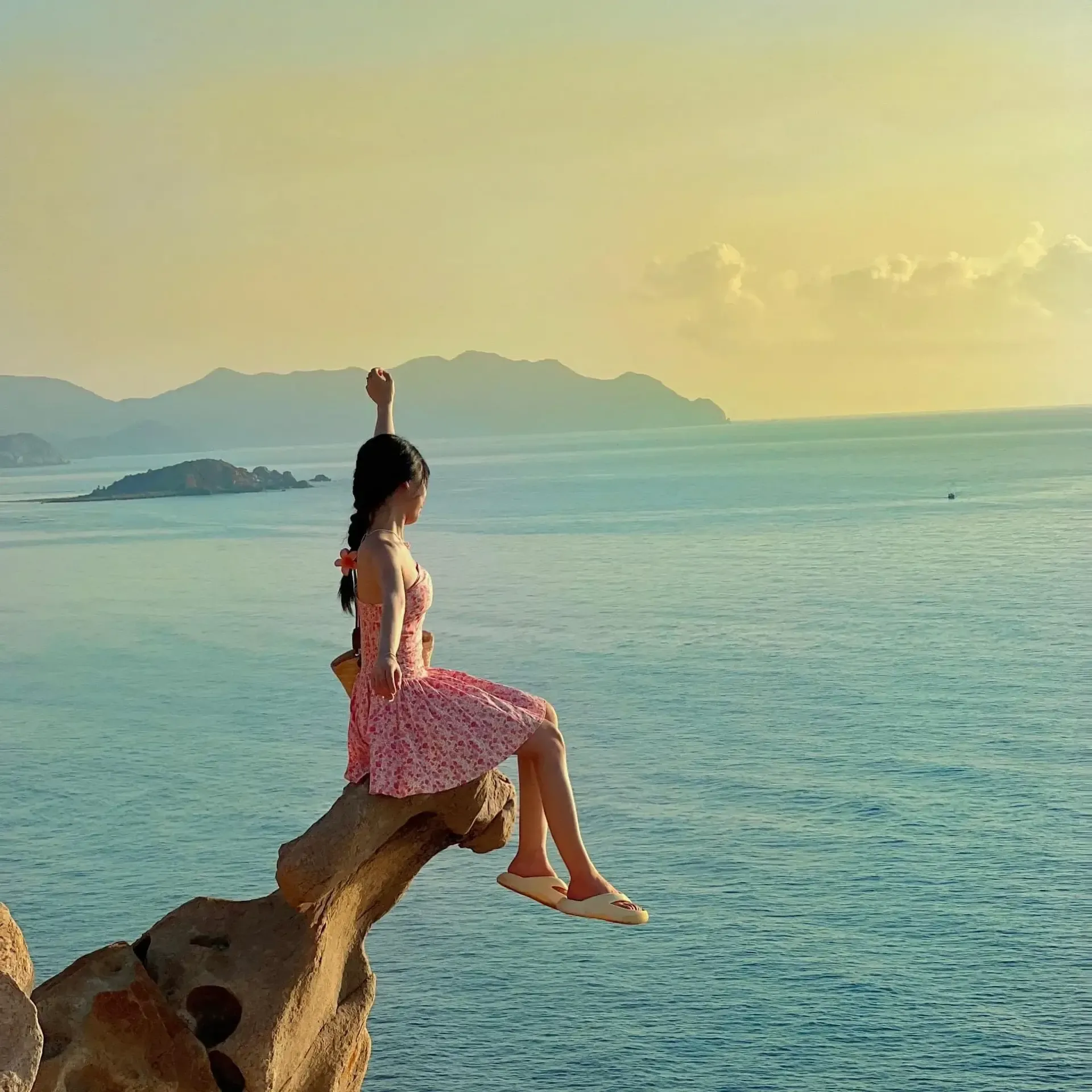 cô gái ngồi trên mũi đá