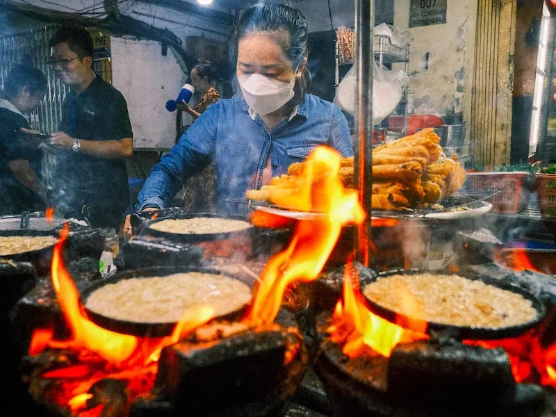 Delicious Street Food Being Cooked by a Vendor on Her Food Stall in Vietnam