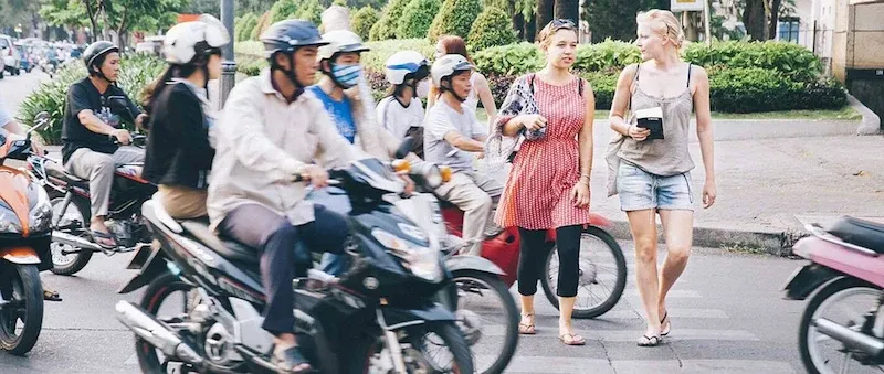 Tourists Crossing a Street in Vietnam During Rush Hour