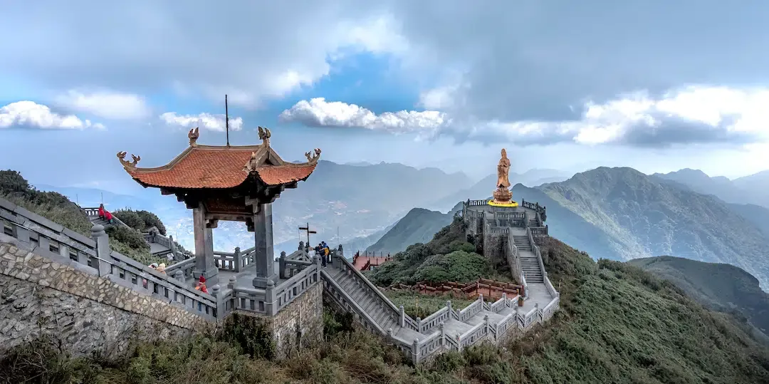 The traditional stone steps and elegant bronze Guan Yin statue at the Sun World Fansipan Legend spiritual complex in Sapa.
