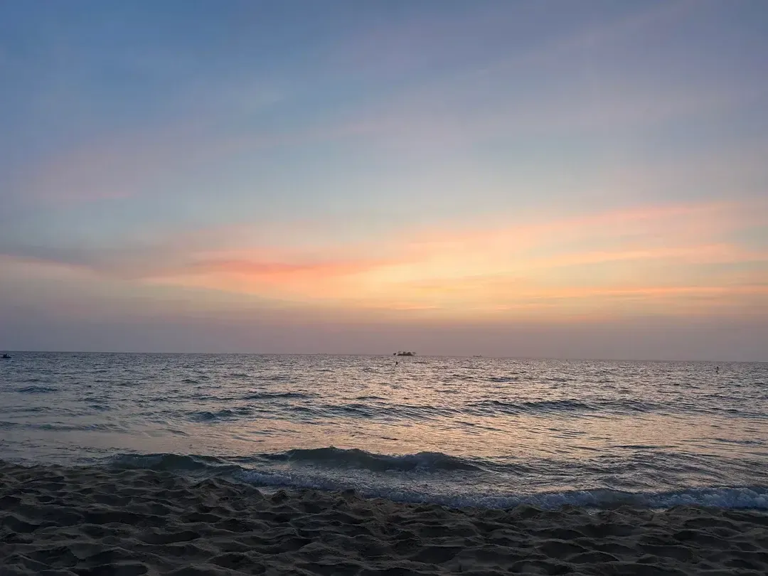 Pastel Sunset Sky Over Calm Waves on a Sandy Beach in Phu Quoc Vietnam