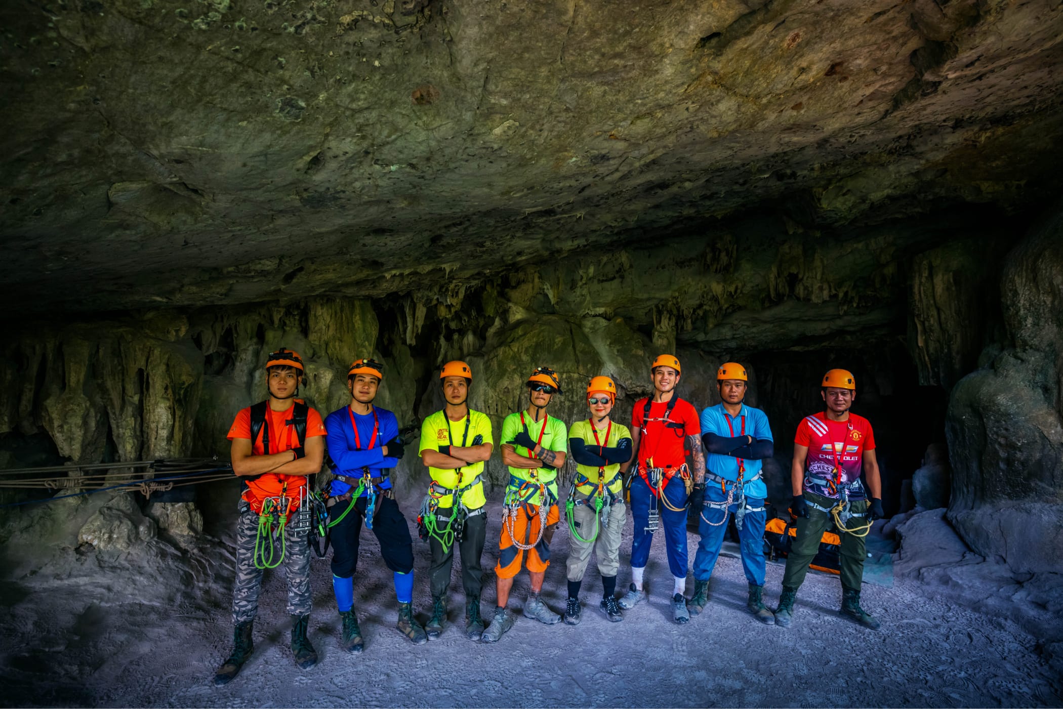Expedition team lined up in helmets, harnesses and full caving kit