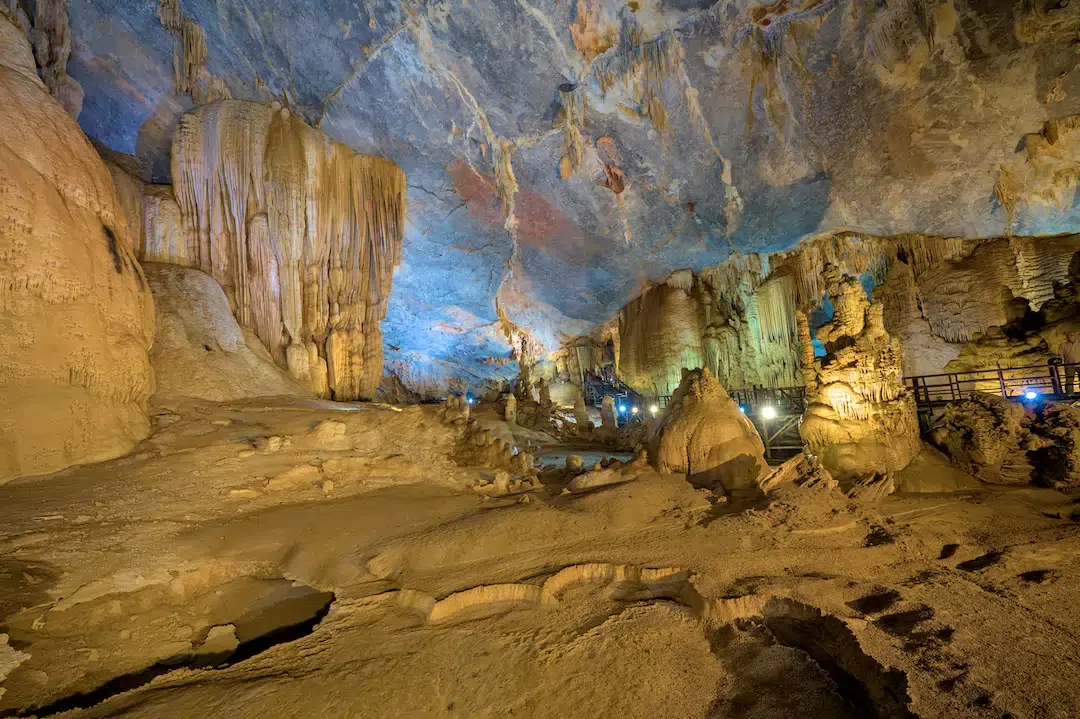 Dramatic stalactites and stalagmite formations lit by colorful lights inside Paradise Cave, Phong Nha-Kẻ Bàng National Park, Vietnam