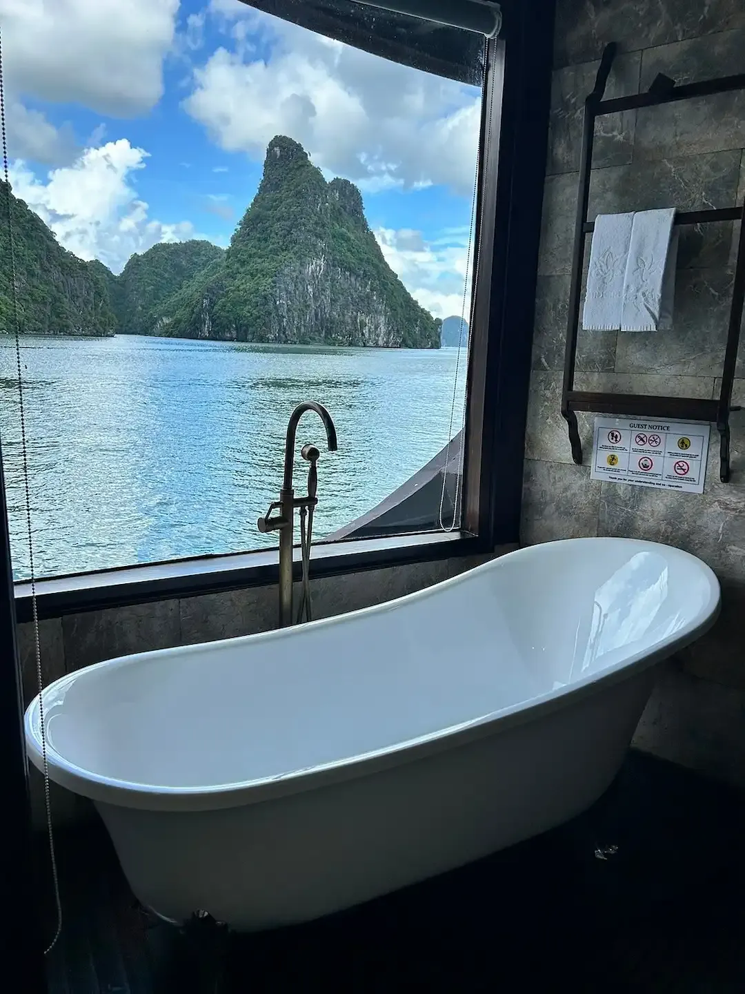 A Narrow Vertical Shot Showing Another Freestanding Bathtub With a Direct Bay View, Emphasizing the Intimate Bathroom Experience Overlooking the Limestone Landscape of Lan Ha Bay.