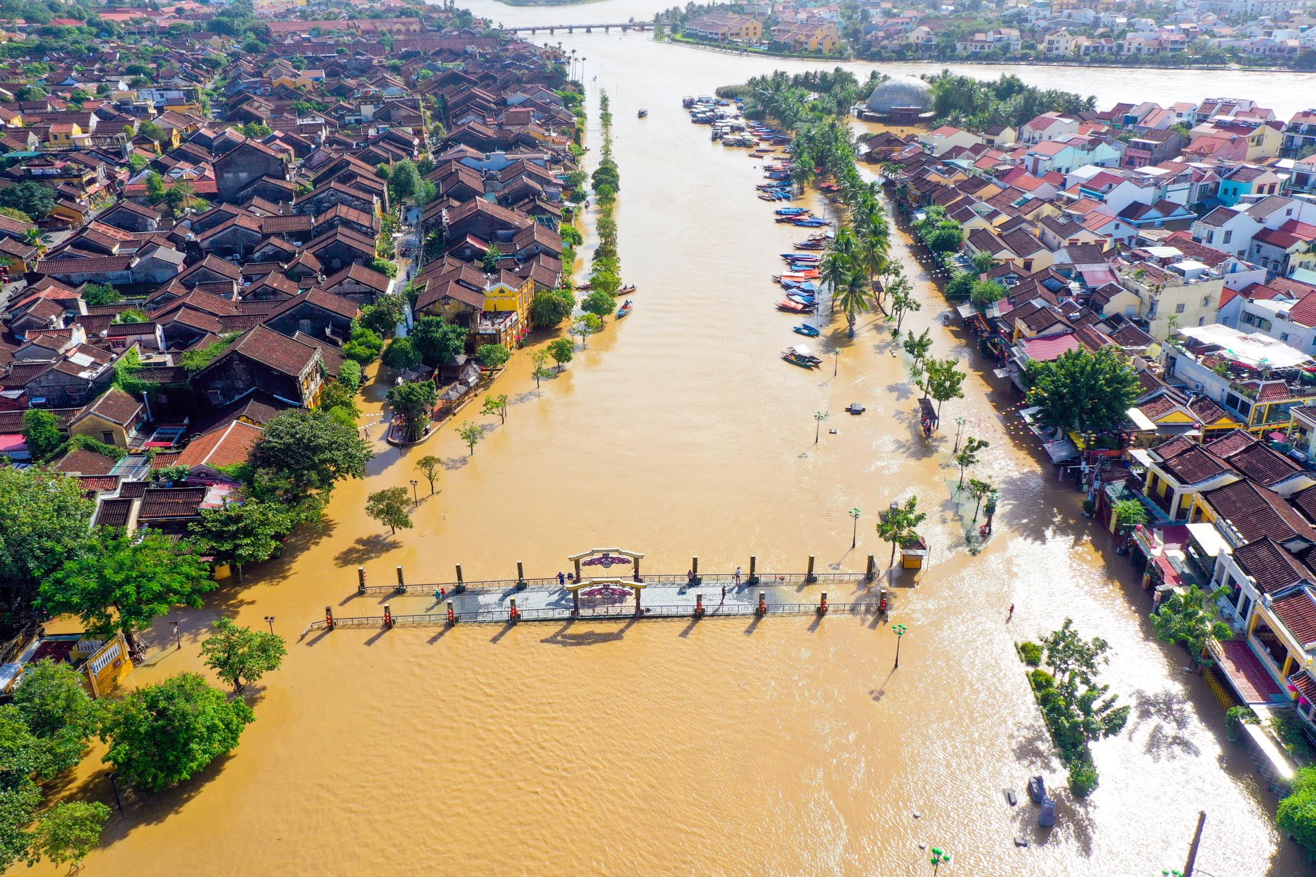 Aerial view of Hoi An old town with the river and waterfront streets under brown floodwater