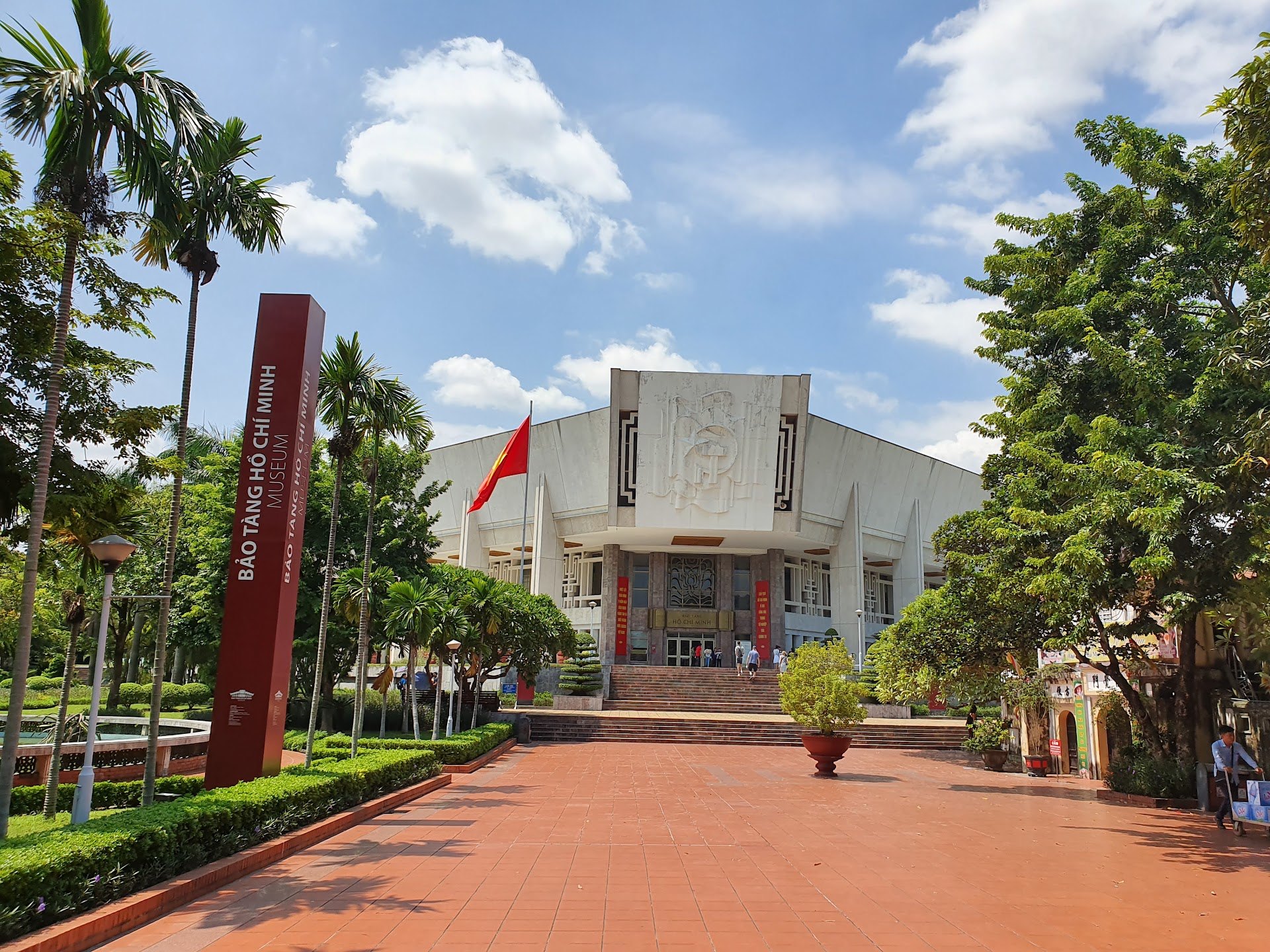 The white Ho Chi Minh Museum building behind a red brick forecourt in Hanoi