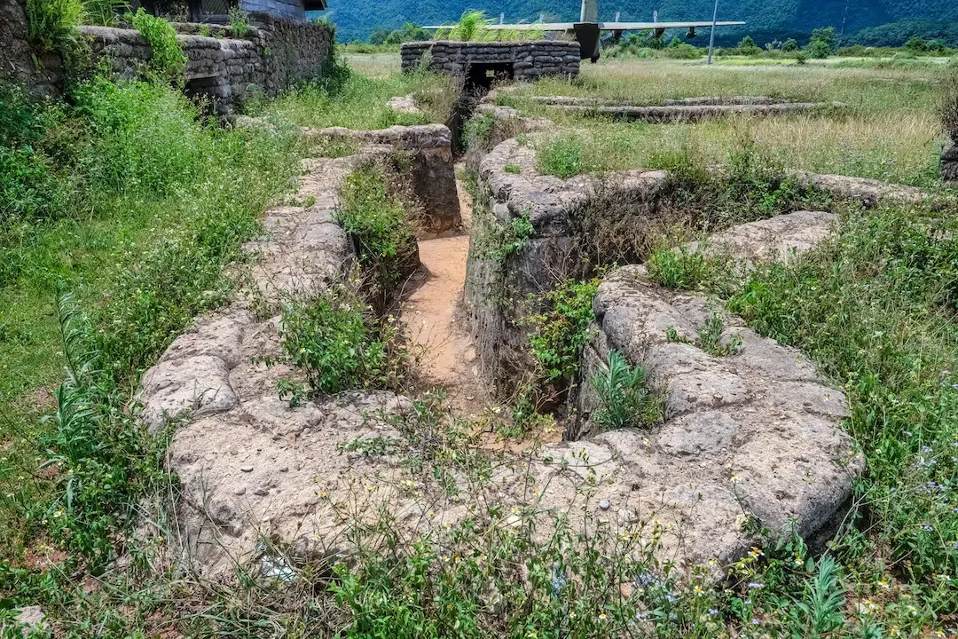 Restored military trenches with sandbags at the Ta Con Airfield historic site in Vietnam