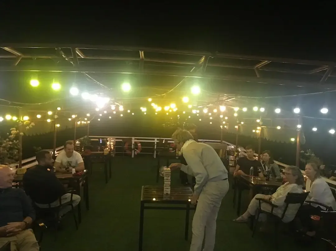 Peaceful Evening on Bai Tu Long Bay Cruise Deck With Warm Lighting, Relaxed Atmosphere, and Intimate Guest Gathering   Authentic Experience Without Party Scene
