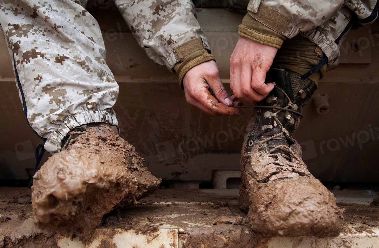 Long socks worn over the outside of trouser legs above muddy canvas trekking boots