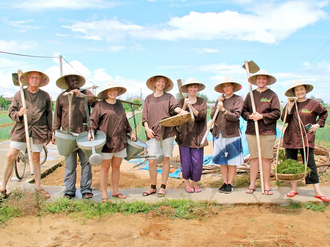 Group of Tourists in Traditional Vietnamese Farming Attire Participating in a Rural Experience