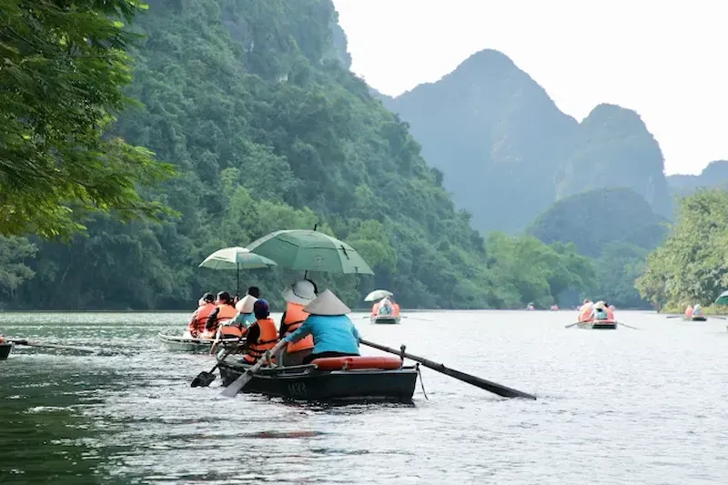 Umbrella Usage in Boat During Rain on Tam Coc Tour