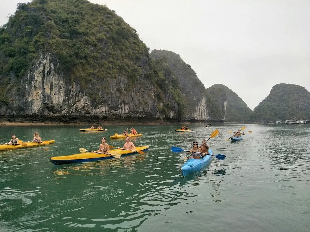 Group of Tourists Kayaking Between Limestone Islands on Tranquil Waters in Lan Ha Bay Vietnam