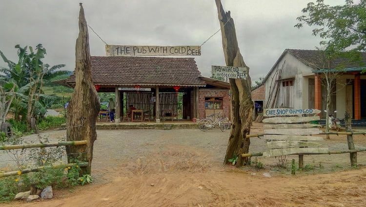 Entrance of a Rustic Pub With Wooden Signage and a Bicycle in Front.