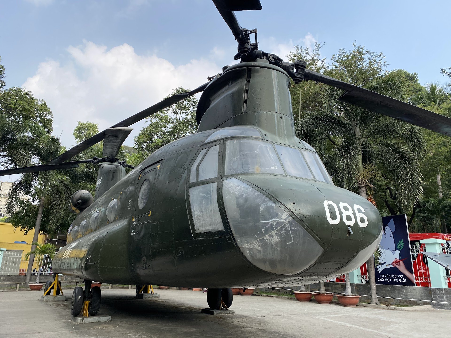 Large green helicopter on display in the War Remnants Museum courtyard