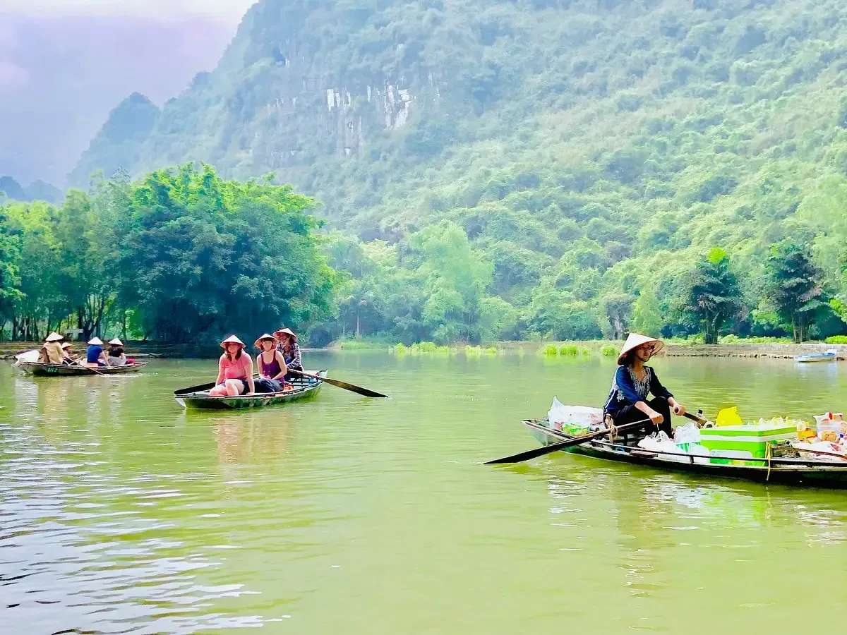 A Vendor Boat in Front of Tourist Boats in Tam Coc River