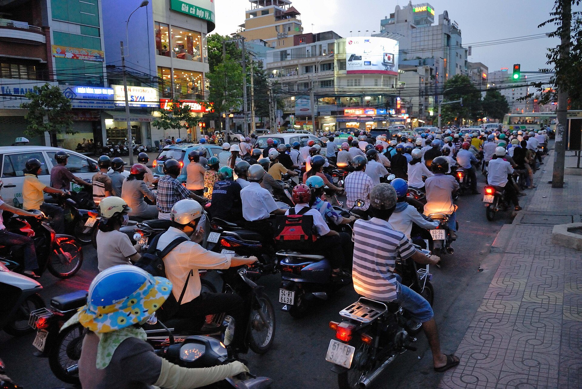 Hundreds of motorbike riders waiting at a junction in Ho Chi Minh City at dusk