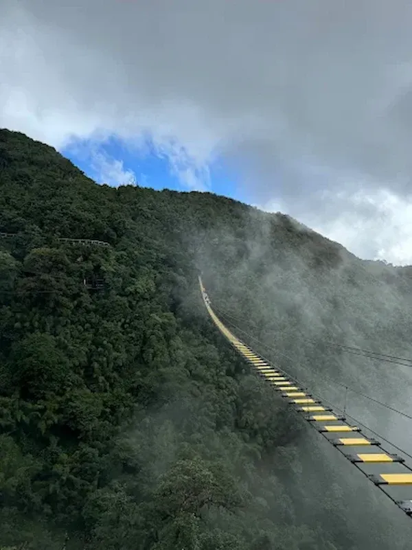 Cloudy Mountain View With a Long Yellow and Black Hanging Bridge at Cầu Kính Rồng Mây, Sapa
