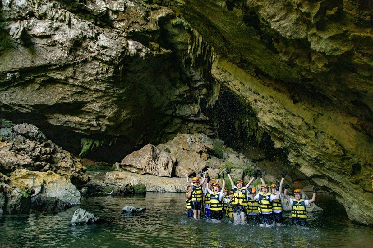 A group of people swimming in Tra Ang Cave of Phong Nha with jungle boss tours