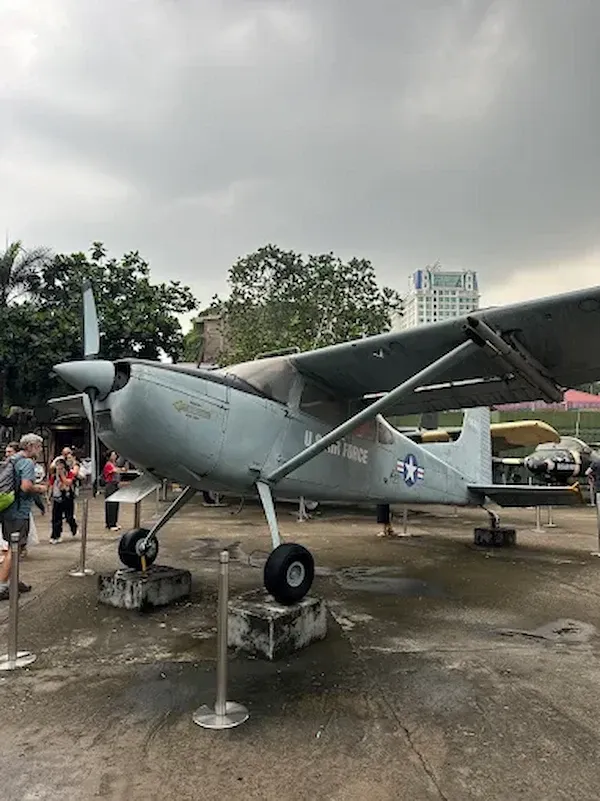 Vintage US military aircraft display at War Remnants Museum in Ho Chi Minh City – Cold War era plane exhibit with visitors