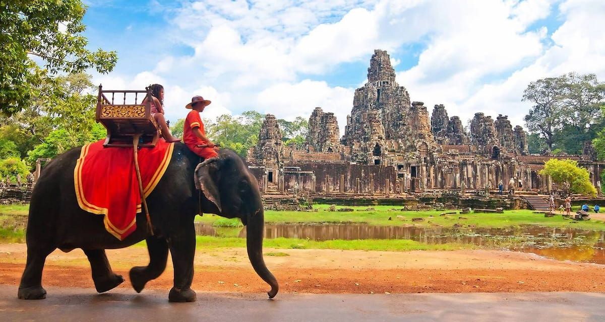 a Person Riding an Elephant Near the Ancient Temple Ruins of Angkor Wat in Cambodia