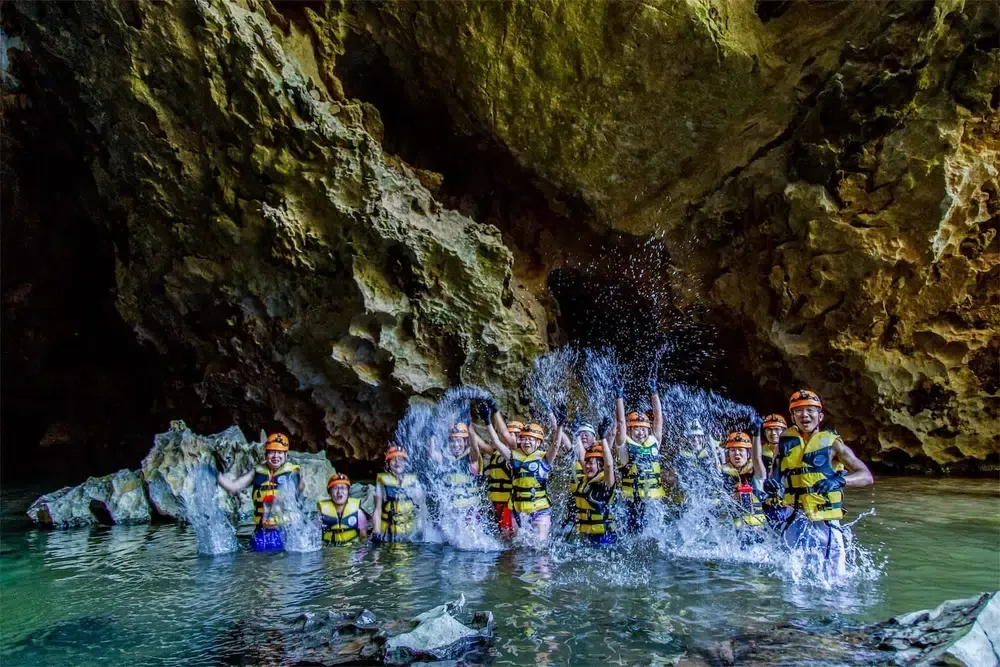 Elephant Cave and Mada Lake Tour of Phong Nha where tourists are in knee deep water ready to swim in water cave