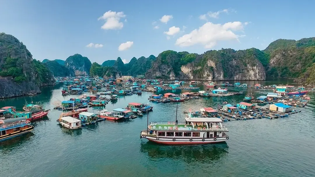 Colorful Floating Fishing Village and Boats Surrounded by Limestone Karsts in Lan Ha Bay Vietnam