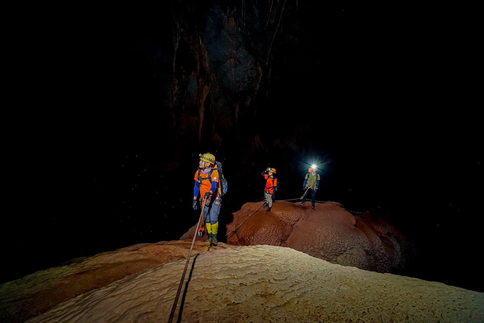 Explorers Inside Hang Pygmy Cave, the Fourth Largest Cave in the World, With Headlamps Illuminating Rock Formations