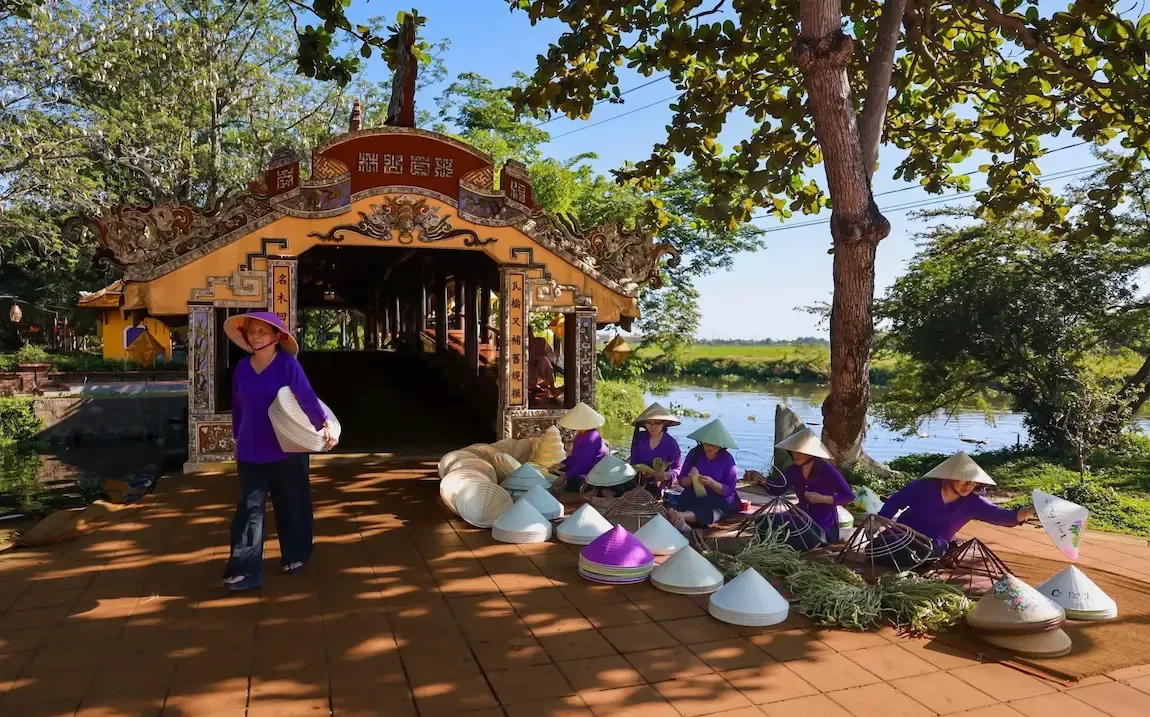 Nghệ nhân làm nón lá trước Cầu Ngói Thanh Toàn