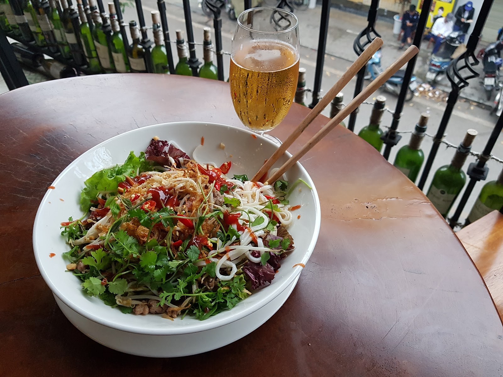 A bowl of Vietnamese noodles on a street side balcony table