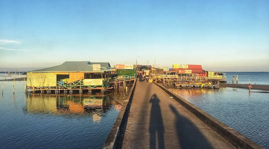 Ham Ninh pier fishing market Phu Quoc with colorful stilt houses morning light waterfront traditional fishing community wooden walkway