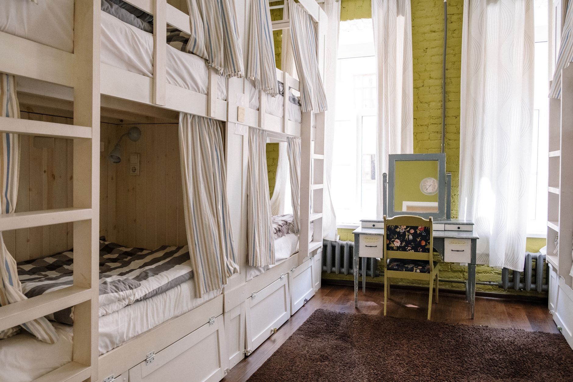 Bunk beds with privacy curtains in a shared hostel dorm room in Vietnam