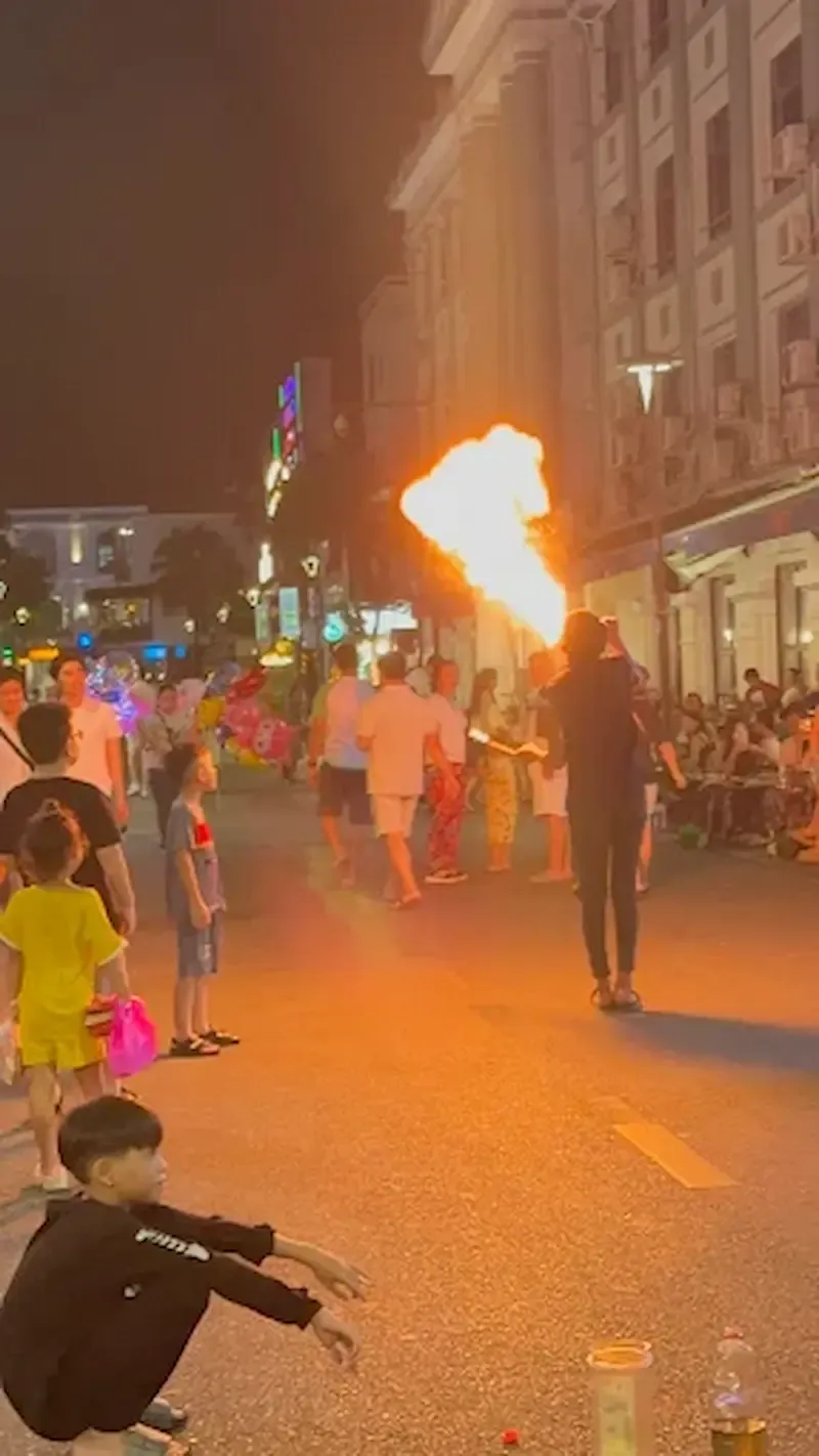a Performer Casually Doing the Dragon Breath Street Performance Right on the Walking Street