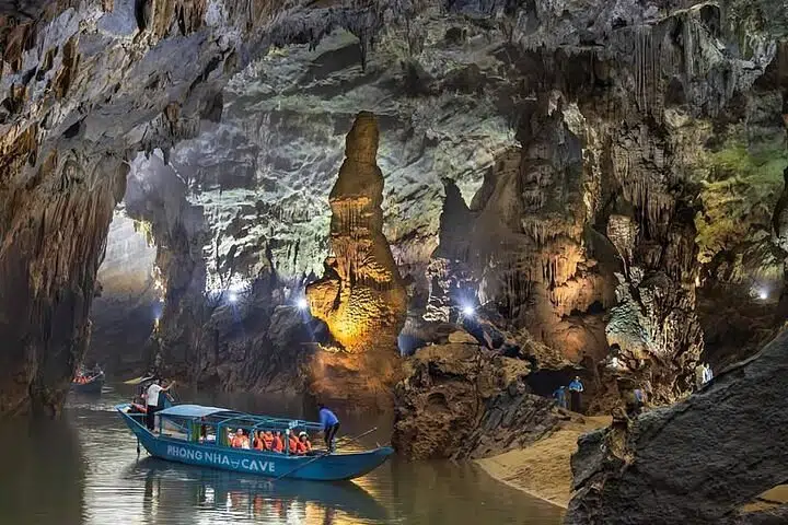 Wooden tour boat entering the river cave mouth at Phong Nha Cave