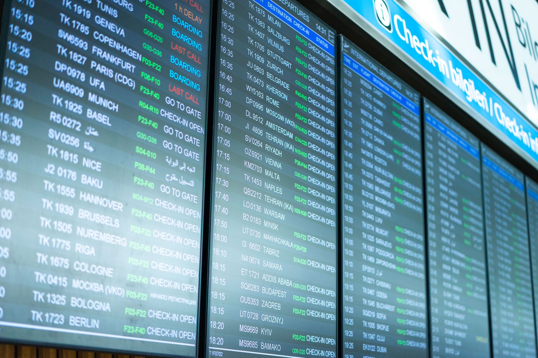 Domestic departure board and waiting passengers in a Vietnamese airport